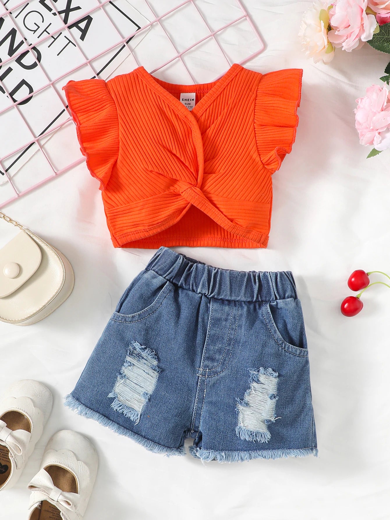 Conjunto infantil com top de manga voadora e shorts rasgados. Estilo e conforto para o verão.