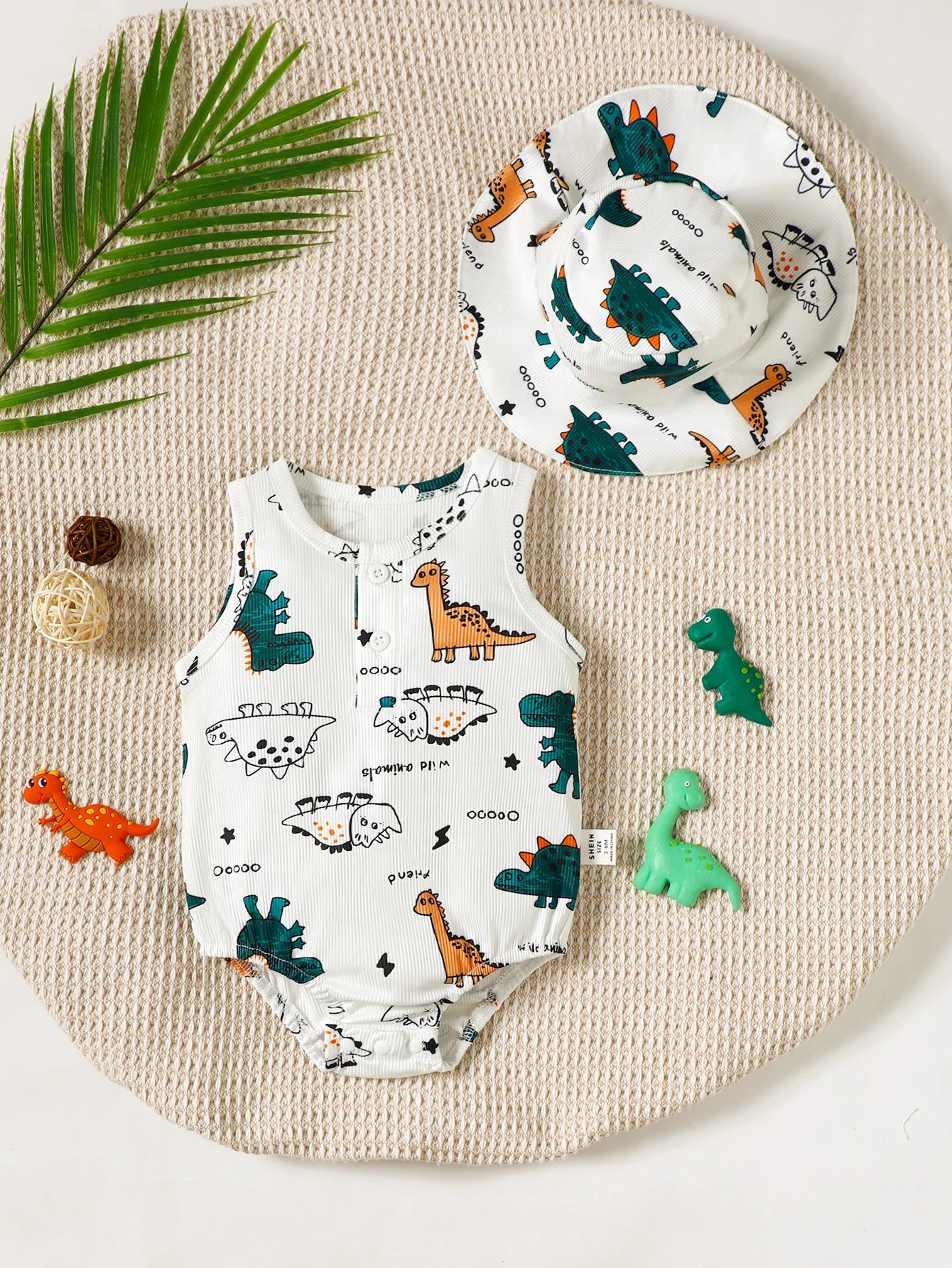 Conjunto bebê com body e chapéu estampados de dinossauro. Conforto e estilo para meninos e meninas. Ideal para o verão!
